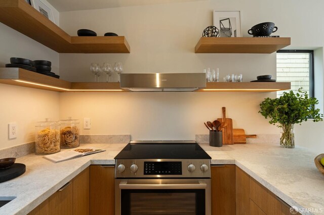 kitchen with stainless steel electric range oven, brown cabinets, and open shelves