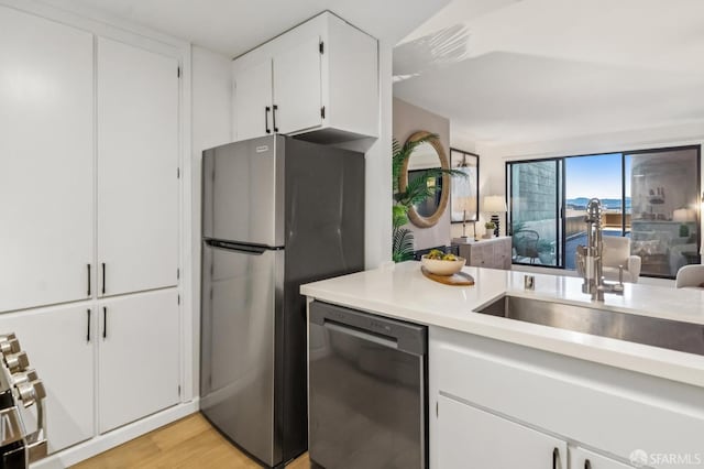 1520 Taylor St Unit 103, San Francisco, CA 94133 - kitchen with stainless steel appliances, light countertops, light wood-style floors, white cabinets, and open floor plan