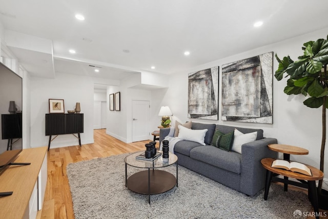 living room with recessed lighting, baseboards, and light wood finished floors