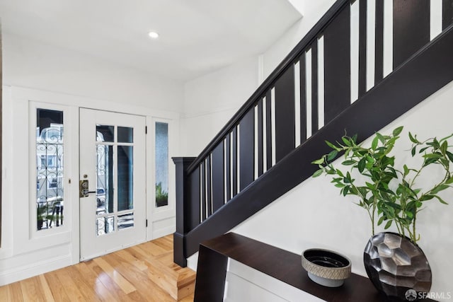 entrance foyer with stairway, recessed lighting, french doors, and wood finished floors