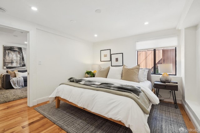 bedroom with recessed lighting, light wood-type flooring, and baseboards