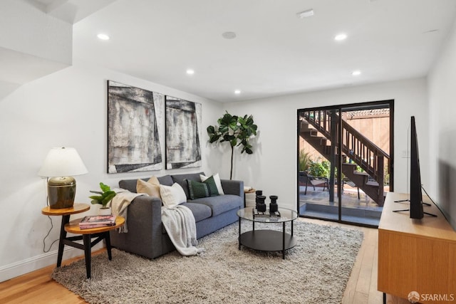 living room featuring stairs, recessed lighting, wood finished floors, and baseboards