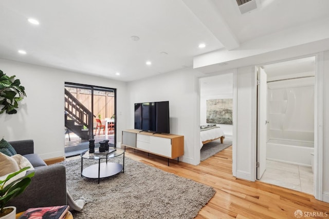 living area with stairway, baseboards, visible vents, recessed lighting, and light wood-type flooring