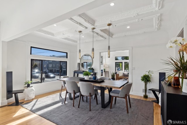 dining area featuring beamed ceiling, coffered ceiling, wood finished floors, a high ceiling, and baseboards