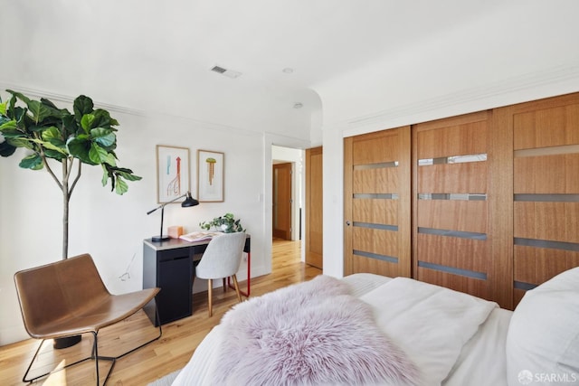 bedroom with a closet, visible vents, and light wood-style flooring