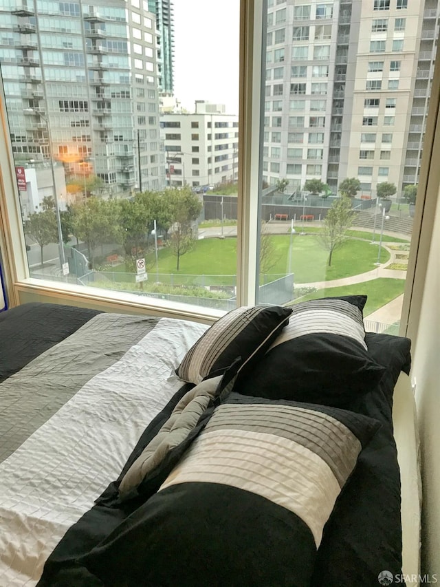 bedroom featuring a view of city and multiple windows