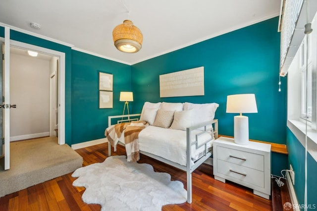 bedroom with baseboards, ornamental molding, and wood finished floors