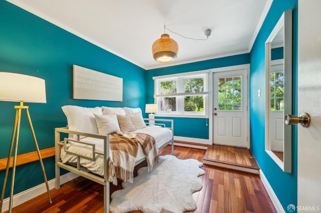 interior space with crown molding, baseboards, and wood finished floors