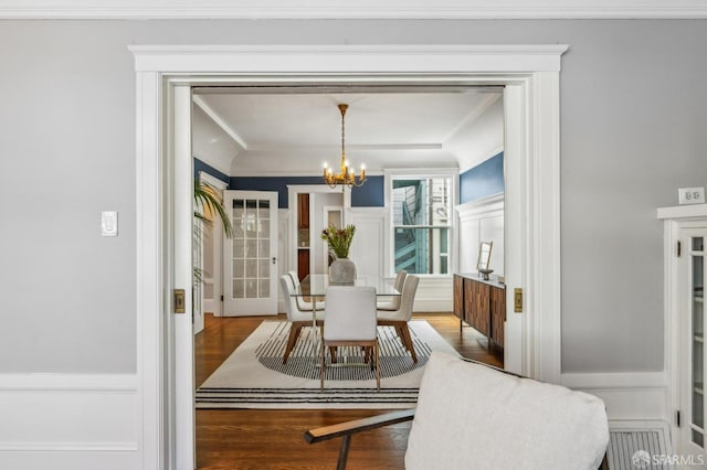 dining space featuring ornamental molding, wood finished floors, and a chandelier
