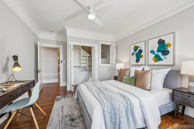 bedroom featuring crown molding, ceiling fan, wood finished floors, and a closet