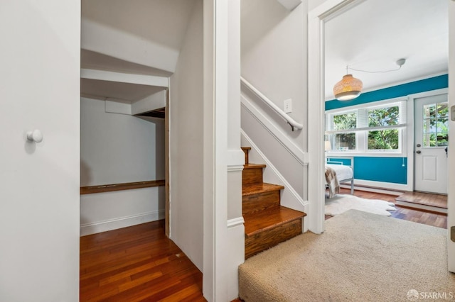 foyer with stairway, baseboards, a baseboard radiator, and wood finished floors