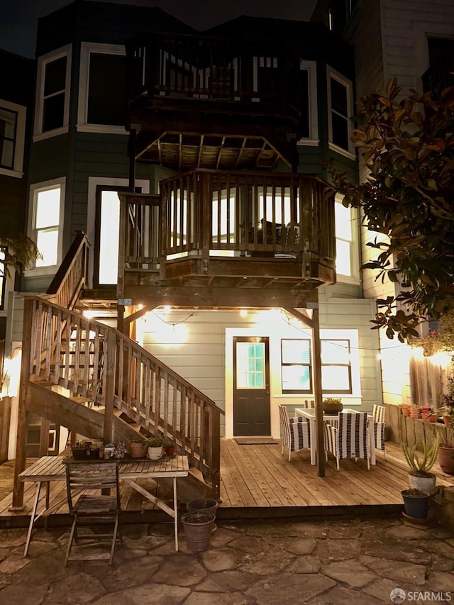 rear view of house featuring a balcony and stairway