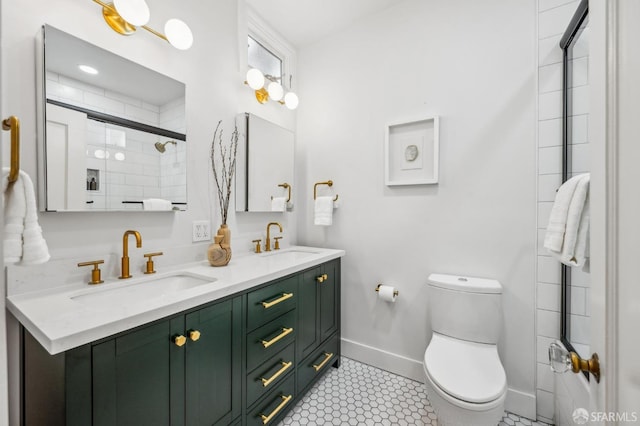 full bath with toilet, baseboards, tiled shower, and a sink