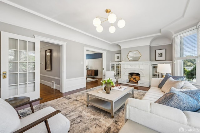 living area with visible vents, wood finished floors, a chandelier, and a fireplace
