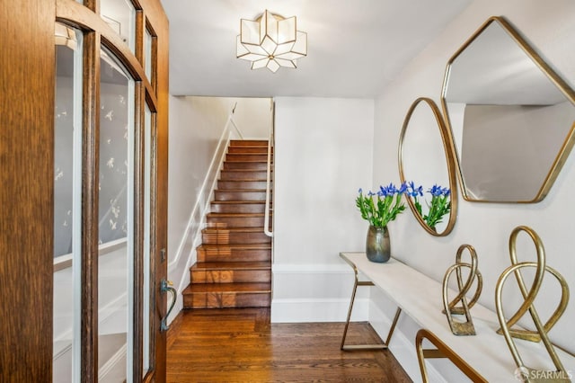 staircase featuring baseboards and wood finished floors
