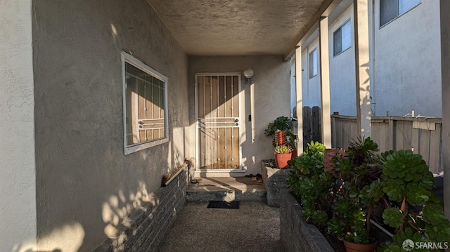 view of home's exterior with stucco siding and fence