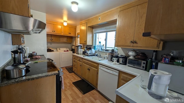 kitchen with white dishwasher, a sink, light wood-style flooring, under cabinet range hood, and independent washer and dryer