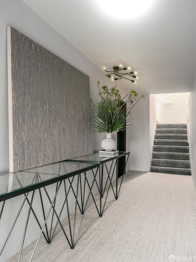 interior space featuring carpet and a chandelier