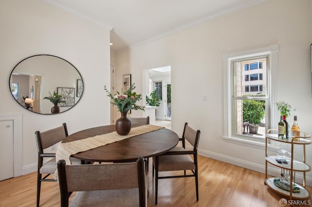 dining space with plenty of natural light, light wood-style flooring, and baseboards