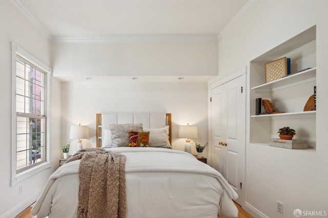 bedroom featuring crown molding, baseboards, and wood finished floors