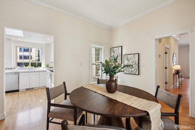 dining room featuring crown molding, light wood-type flooring, and visible vents