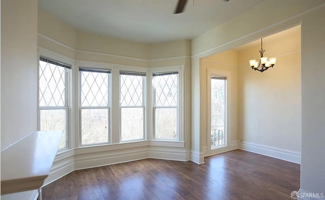 empty room featuring dark hardwood / wood-style floors and ceiling fan with notable chandelier