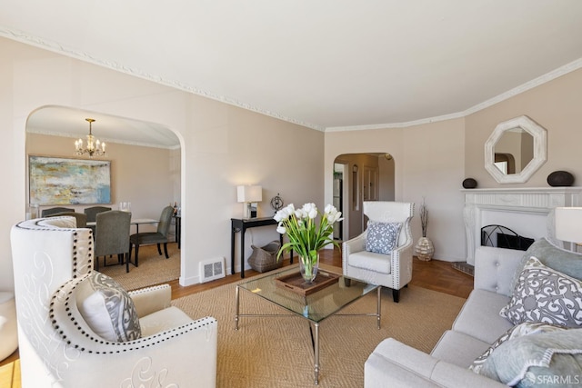 1874 34th Ave, San Francisco, CA 94122 - living area featuring arched walkways, a chandelier, ornamental molding, wood finished floors, and a fireplace with raised hearth