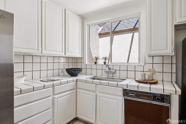 1874 34th Ave, San Francisco, CA 94122 - kitchen featuring dishwashing machine, white cabinetry, and tasteful backsplash