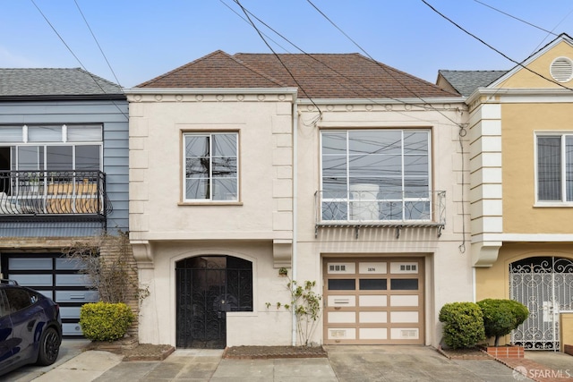1874 34th Ave, San Francisco, CA 94122 - view of front of house with stucco siding, a garage, a balcony, and concrete driveway