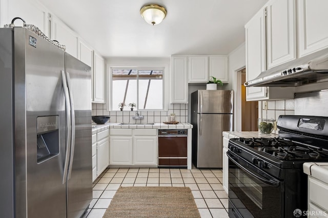 1874 34th Ave, San Francisco, CA 94122 - kitchen with stainless steel refrigerator with ice dispenser, black range with gas cooktop, freestanding refrigerator, tile countertops, and under cabinet range hood