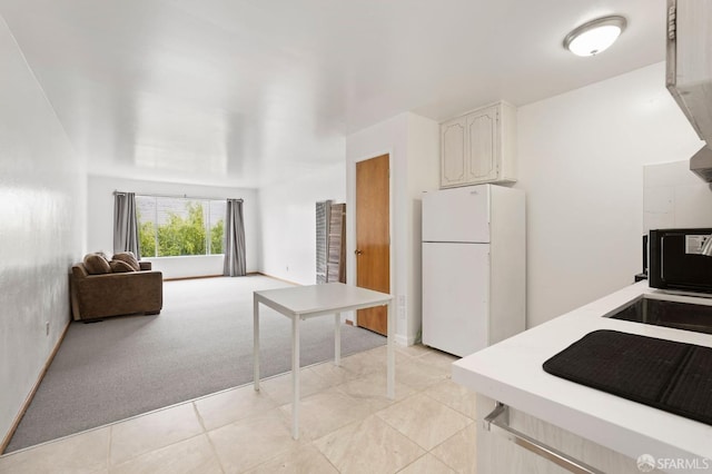 kitchen with white cabinetry, light colored carpet, and white refrigerator