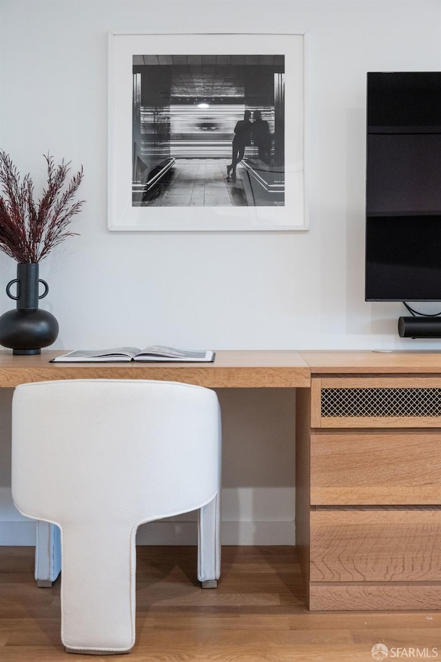 interior details featuring built in desk and wood finished floors