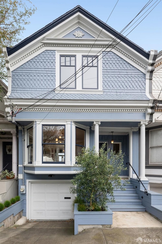 greek revival house featuring an attached garage and driveway