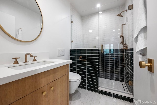 bathroom featuring vanity, a shower stall, and toilet