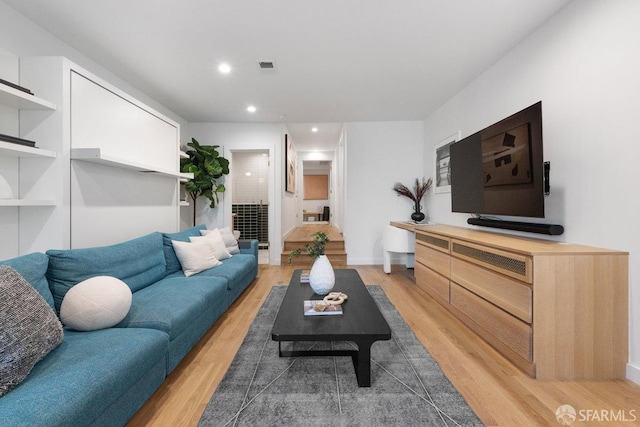 living area featuring light wood-style floors, baseboards, visible vents, and recessed lighting