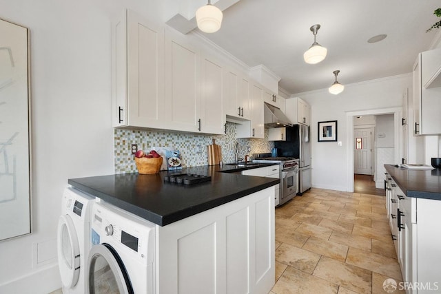 kitchen with high end stove, under cabinet range hood, independent washer and dryer, decorative backsplash, and dark countertops