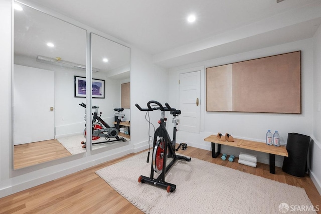 exercise area featuring recessed lighting, baseboards, and wood finished floors