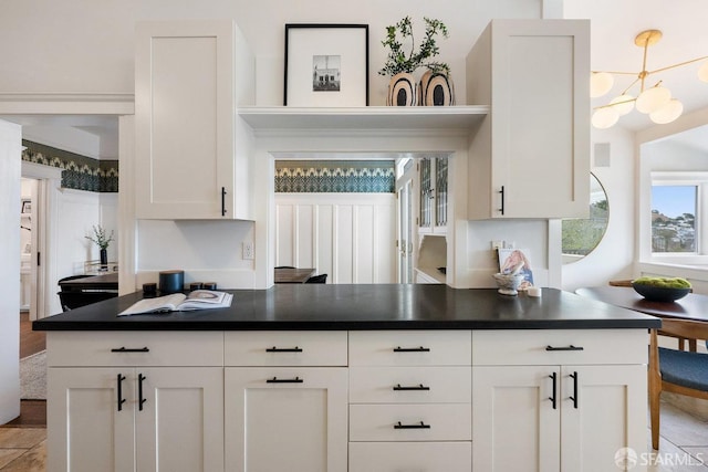 kitchen featuring a chandelier, dark countertops, and white cabinets