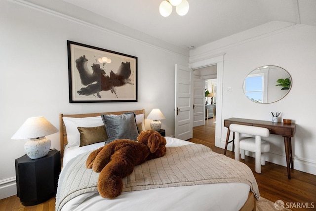 bedroom featuring crown molding, baseboards, and wood finished floors