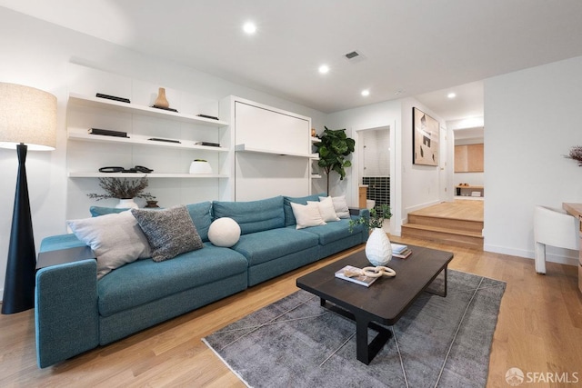 living area featuring visible vents, baseboards, light wood-style flooring, and recessed lighting