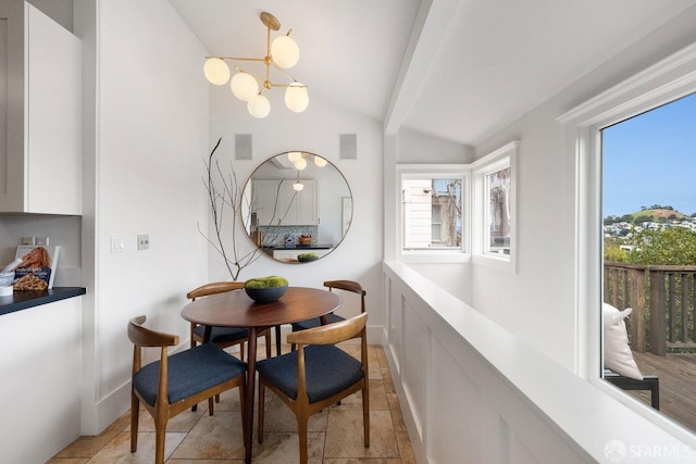 dining area featuring lofted ceiling with beams, baseboards, and a notable chandelier