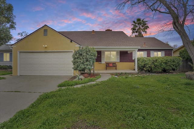 single story home featuring a garage and a lawn