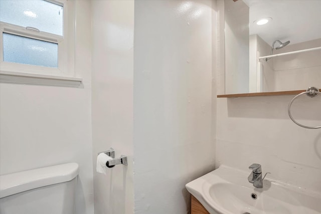 bathroom with toilet, vanity, and walk in shower