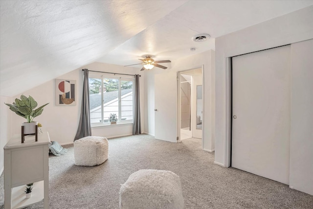 bedroom featuring lofted ceiling, a textured ceiling, ceiling fan, and carpet floors