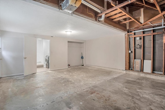 basement with washing machine and clothes dryer and a textured ceiling