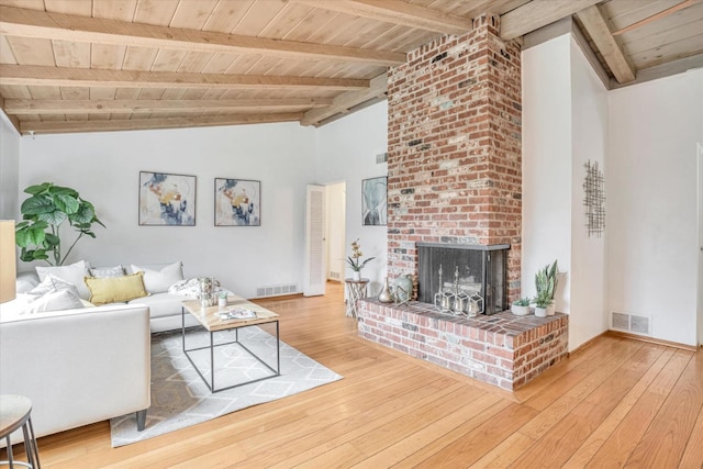 unfurnished living room with a brick fireplace, hardwood / wood-style flooring, wooden ceiling, and vaulted ceiling with beams