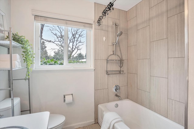 bathroom featuring tiled shower / bath and toilet