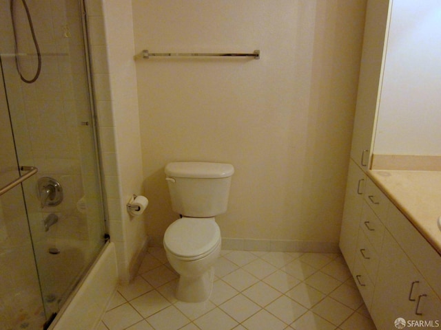 bathroom with toilet, bath / shower combo with glass door, vanity, baseboards, and tile patterned floors