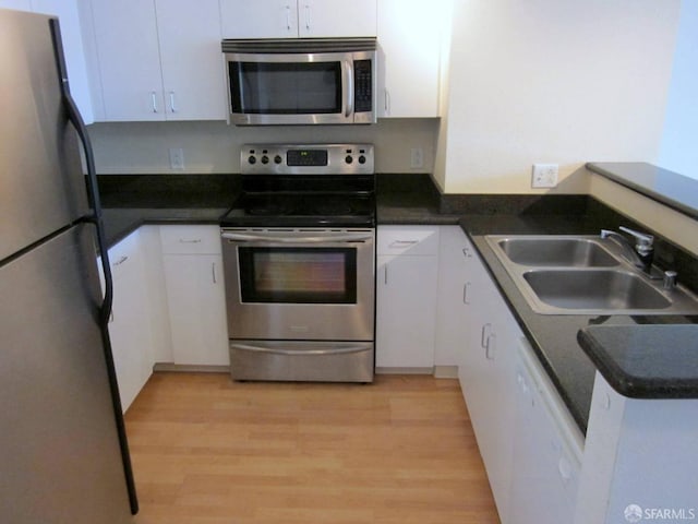 kitchen featuring white cabinets, stainless steel appliances, and a sink