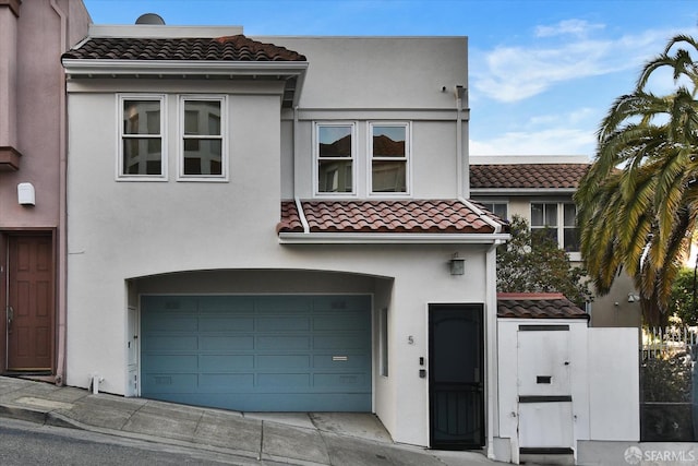 view of front facade featuring a garage, concrete driveway, stucco siding, and a tiled roof